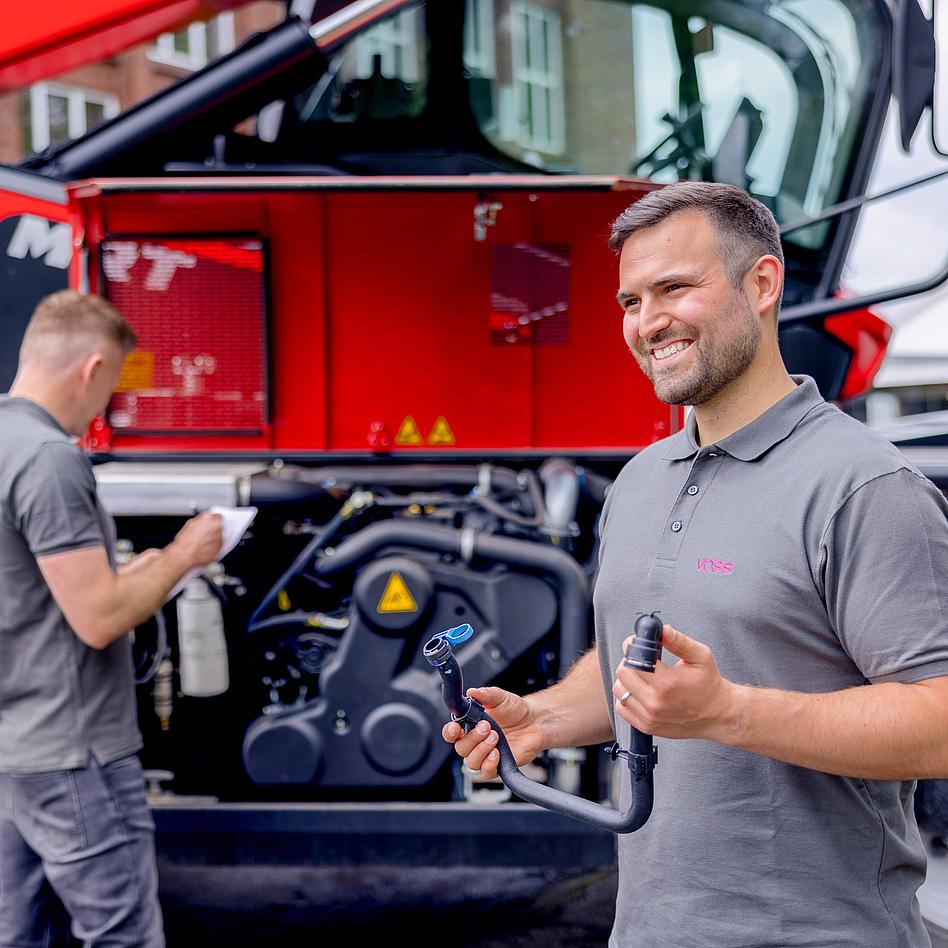 VOSS Mitarbeiter hält eine Verbindungslösung in der Hand.