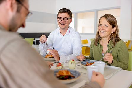 Glückliche Mitarbeiter die im VOSS Bistro zu Mittag essen