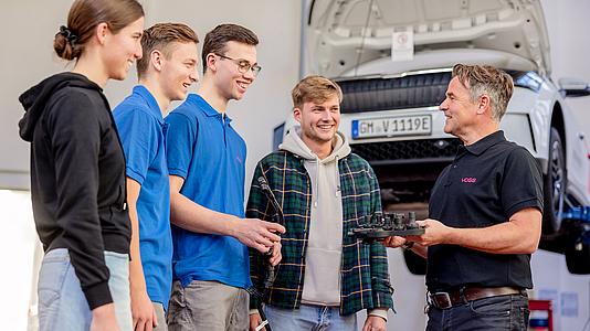 VOSS Mitarbeiter im Gespräch mit vier jungen Menschen.