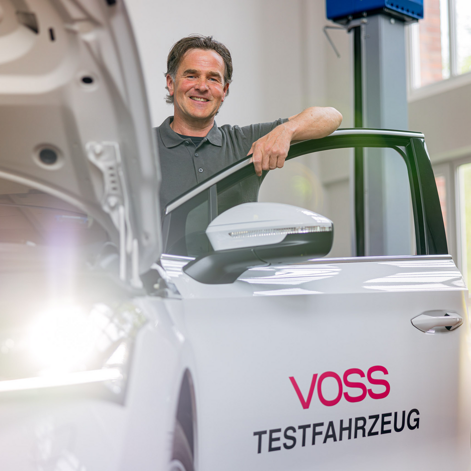 Ein VOSS Mitarbeiter in einem an einem VOSS Testfahrzeug.