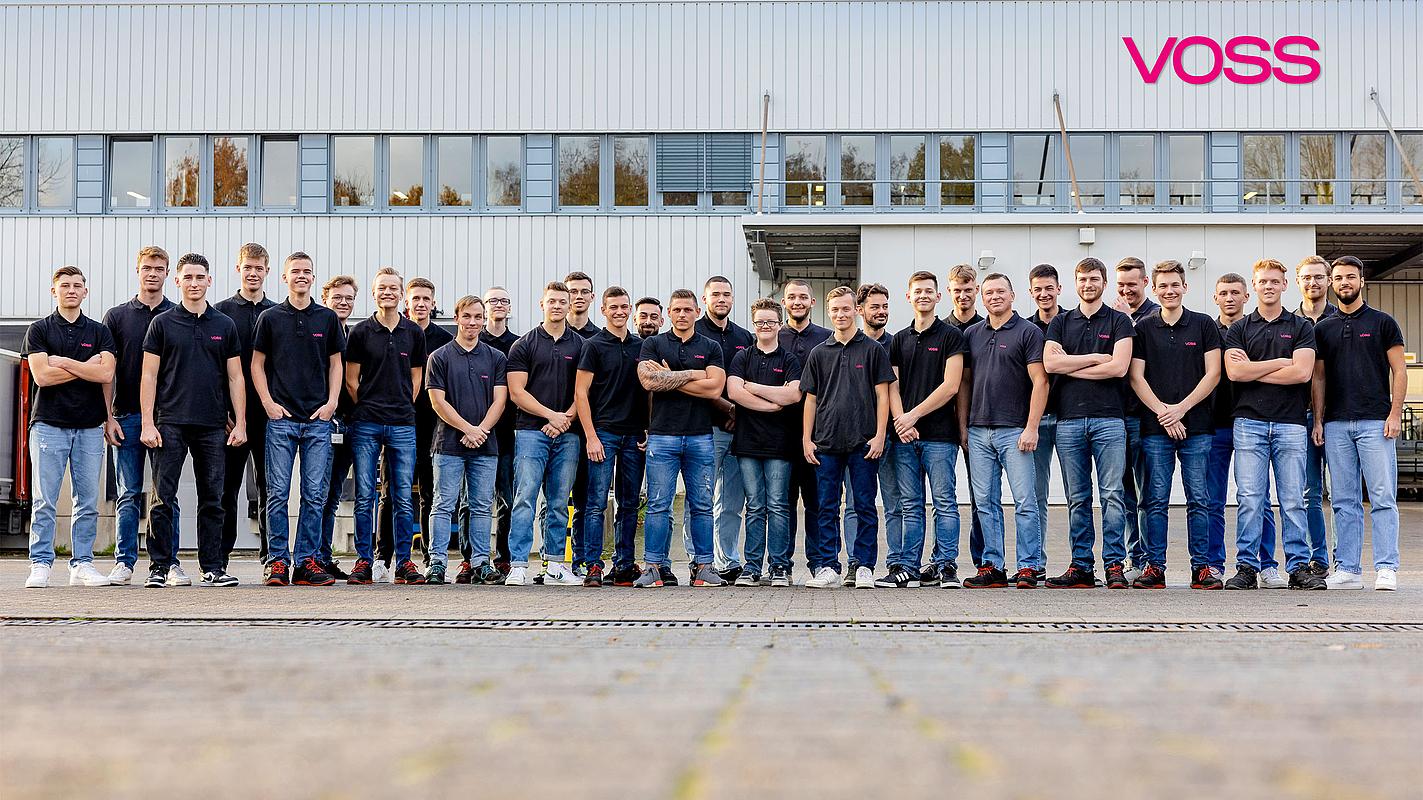 Gruppenbild von jungen Männern vor einem VOSS Gebäude