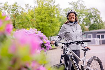 Junge Frau mit Mountainbike in der Hand