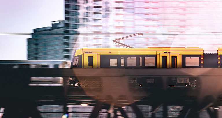 Gelbe Straßenbahn auf einer Brücke.